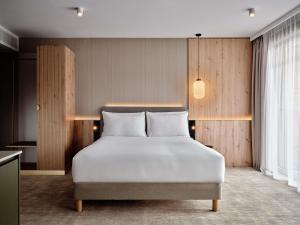 a bedroom with a white bed in a room at Mövenpick Resort & Spa Karpacz in Karpacz