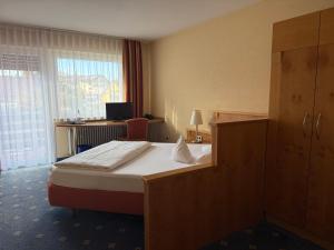 ein Hotelzimmer mit Bett und Schreibtisch in der Unterkunft Hotel Altenberg in Baden-Baden