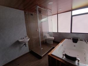 a bathroom with a shower and a tub and a sink at Hotel Páramo de Sumapaz in San Juan +17 photos