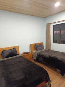 a bedroom with two beds and a window at Hotel Páramo de Sumapaz in San Juan