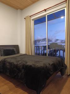 a bedroom with a bed and a large window at Hotel Páramo de Sumapaz in San Juan