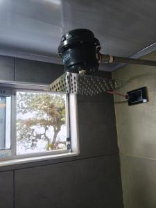 a pot hanging from a ceiling in front of a window at Hotel Páramo de Sumapaz in San Juan