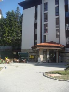 un edificio con mesas y sillas en un patio en Apart Hotel Flora Residence Daisy, en Borovets