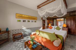a bedroom with a large bed and a couch at Hoi An Chic - Green Retreat in Hoi An