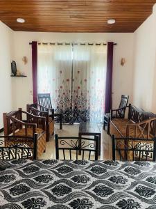 a room with chairs and a bed and curtains at Veenu Homestay in Badulla