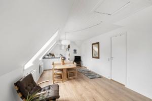 a living room with a table and a kitchen at Holiday Apartment On Bornholm With Sea View in Svaneke