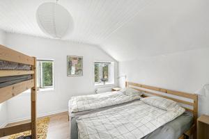 a bedroom with a bed and two windows at Holiday Apartment On Bornholm With Sea View in Svaneke