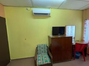 a room with a green wall with a tv and a table at White House Hotel Kluang in Kluang