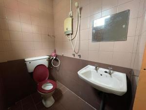 a bathroom with a toilet and a sink at White House Hotel Kluang in Kluang