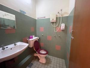 a bathroom with a pink toilet and a sink at White House Hotel Kluang in Kluang +19 photos
