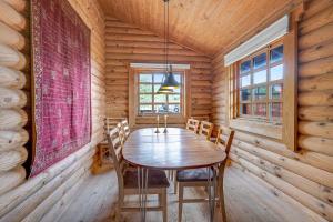 a dining room with a wooden table and chairs at Charming Cabin With Wilderness Hot Tub in Asnæs +15 photos
