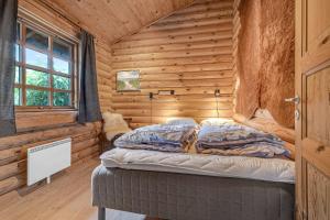 a bedroom with a bed in a log cabin at Charming Cabin With Wilderness Hot Tub in Asnæs