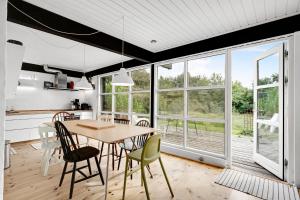 a kitchen and dining room with a table and chairs at Lovely Beach Home Enveloped In Green Surroundings in Ebeltoft