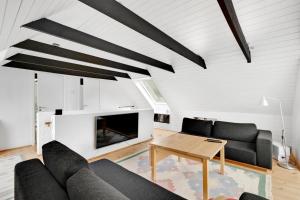 a living room with a couch and a table at Lovely Beach Home Enveloped In Green Surroundings in Ebeltoft