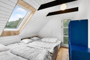 two beds in a room with a window at Lovely Beach Home Enveloped In Green Surroundings in Ebeltoft