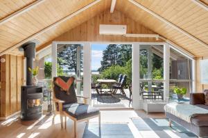 ein Wohnzimmer mit einem Holzofen in einem Haus in der Unterkunft Schönes Sommerhaus Mit Herrlichem Blick in Ølsted