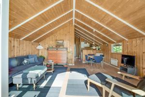 ein Wohnzimmer mit Sofa und ein Esszimmer in der Unterkunft Schönes Sommerhaus Mit Herrlichem Blick in Ølsted