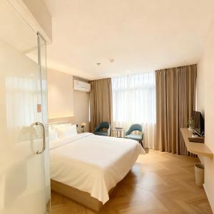 a hotel room with a bed and a glass door at Shenzhen Green Oasis Hotel, Baoan in Bao'an +19 photos