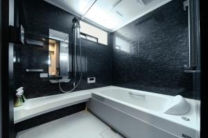 a bathroom with a tub and a shower and a sink at ulu Tokyo in Tokyo +13 photos