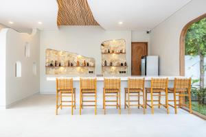 a kitchen with a bar with rattan chairs at DESAULU VILLAS - Boutique Private Room Pool View in Uluwatu