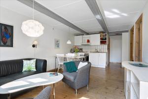 a living room with a couch and a table at Holiday Apartment In Peaceful Surroundings in Neksø