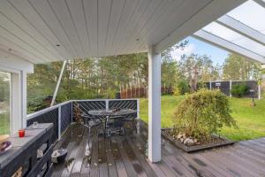 a wooden deck with a table and chairs on it at Close To The Beach And Forest And Ebeltoft in Ebeltoft
