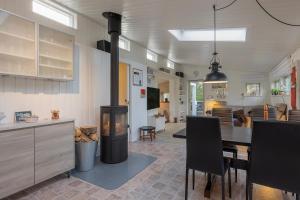 a kitchen and dining room with a wood burning stove at Close To The Beach And Forest And Ebeltoft in Ebeltoft