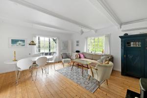 a living room with a couch and a table at Charming Cottage Near The Beach in Neksø
