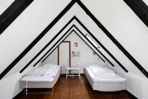 two beds in a room with white walls at Charming Cottage Near The Beach in Neksø