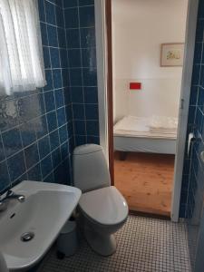 a bathroom with a toilet and a sink and a tub at Charming Cottage Near The Beach in Neksø +27 photos