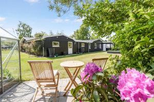 a patio with two chairs and a table and some flowers at Unique Holiday Home In Quiet Surroundings in Storvorde