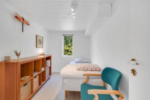 a bedroom with a bed and a chair at Unique Holiday Home In Quiet Surroundings in Storvorde