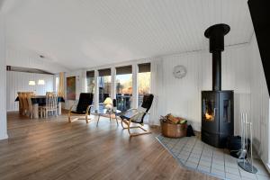 a living room with a wood burning stove in it at Cozy Summer House On Scenic Djursland in Glesborg