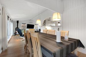 a dining room and kitchen with a table and chairs at Cozy Summer House On Scenic Djursland in Glesborg