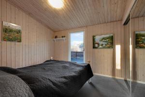 a bedroom with a bed in a room with a window at Cozy Summer House On Scenic Djursland in Glesborg