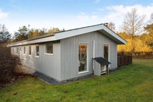 a small gray shed with a large window at Cozy Summer House On Scenic Djursland in Glesborg