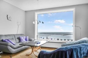 a living room with a couch and a large window at Spacious House With Sea Views From All Rooms in Rønne