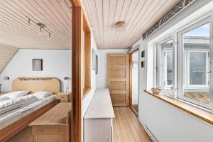 a bedroom in a tiny house with a bed and a window at Spacious House With Sea Views From All Rooms in Rønne