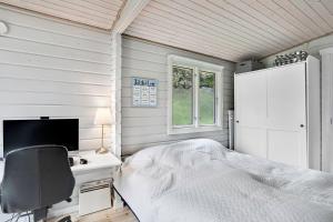 a bedroom with a bed and a desk and a computer at The Sun House in Hundested