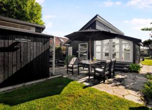 a patio with a table and an umbrella at Exclusive Architect Designed Beach House in Karrebæksminde