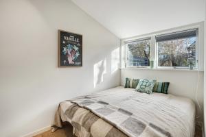 a bedroom with a bed and two windows at Unique New Beach-House I Seaview And Space in Vejby