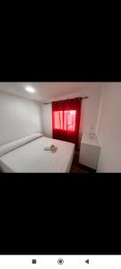 a room with a bed with a red window at chalecito con piscina y barbacoa in Benicarló