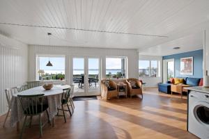 eine Küche und ein Wohnzimmer mit Tisch und Stühlen in der Unterkunft Neu Restauriertes Sommerhaus Mit Meerblick in Aabenraa