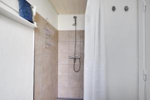 ein Badezimmer mit Dusche und Duschvorhang in der Unterkunft Neu Restauriertes Sommerhaus Mit Meerblick in Aabenraa + 17 Fotos