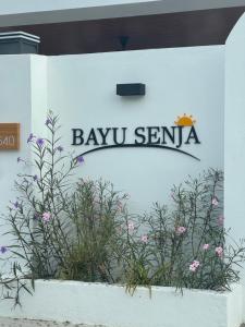 a sign for the bayu sentina on a wall with flowers at Bayu senja in Lahad Datu