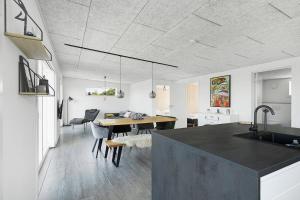 a kitchen and living room with a table and a dining room at Modern Holiday Home On Adventurous Bornholm in Allinge