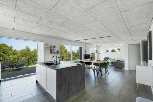 a kitchen and living room with a table and chairs at Modern Holiday Home On Adventurous Bornholm in Allinge