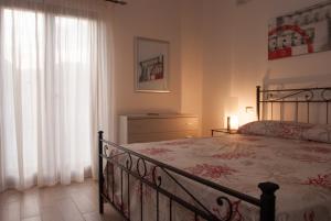 ein Schlafzimmer mit einem Bett und einem Fenster in der Unterkunft Casa vacanza Leucosia&Tresino in Santa Maria di Castellabate