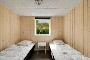 two beds in a room with a window at Modern Holiday Home On Adventurous Bornholm in Allinge