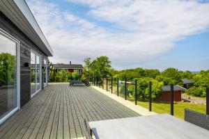 a deck with a bench on the side of a house at Modern Holiday Home On Adventurous Bornholm in Allinge +14 photos